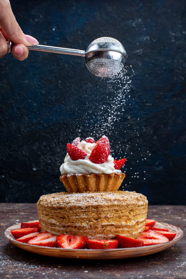 front-view-cake-slice-with-cream-fresh-red-strawberries-inside-plate-getting-sugar-powder-dark-background